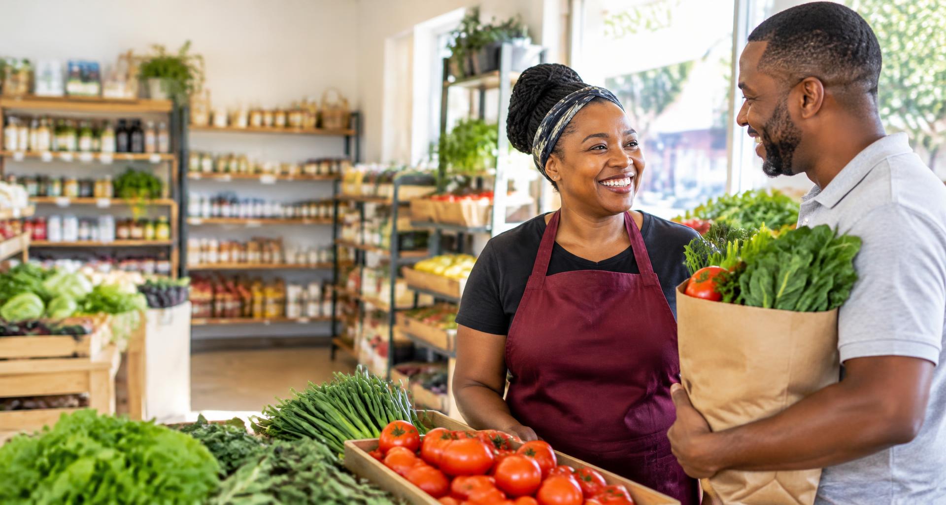 A South African shop owner welcoming a customer buying fresh groceries